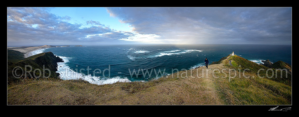 Image of Panorama looking from Cape Maria van Diemen around past Columbia Banks to the Cape Reinga (Te Rerengawairua) lighthouse with first rays of dawn. Walker on ridge, Cape Reinga, Far North District, Northland Region, New Zealand (NZ) stock photo image