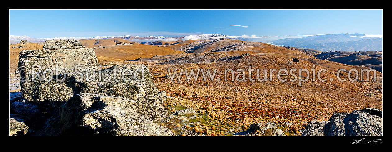 Image of Looking along the alpine tussock and Rock tor covered Carrick Range towards Lake Dunstan by Cromwell. Pisa Range distant centre. Light frost, Bannockburn, Central Otago District, Otago Region, New Zealand (NZ) stock photo image