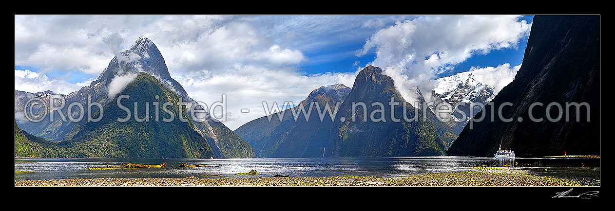 Image of Milford Sound Panorama, Fiordland National Park. Small boat tour leaving Freshwater Basin. Mitre Peak left (1683m), Stirling Falls centre, The Lion and Mt Pembroke (2015m) right, Milford Sound, Fiordland National Park, Southland District, Southland Region, New Zealand (NZ) stock photo image