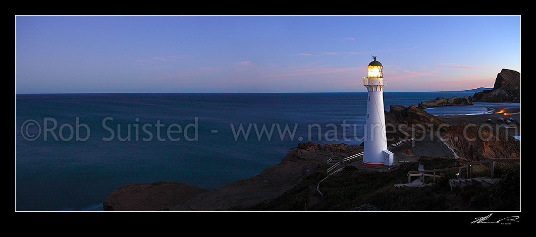 Image of Castlepoint Lighthouse (1913) at dusk, looking across reef, sandbar and lagoon towards Castle rock (162m). Castlepoint scenic reserve. Panorama, Castlepoint, Masterton District, Wellington Region, New Zealand (NZ) stock photo image