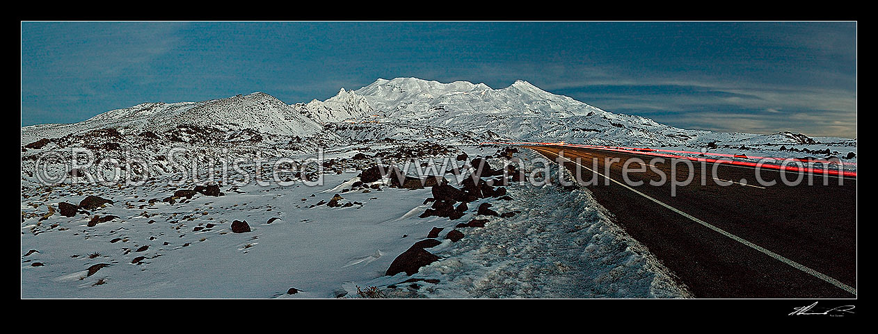 Image of Mount Ruapehu (2797m) at dusk, looking up the Bruce Road to Iwikau village lights and Whakapapa Skifield with snow groomers lights visible. Panorama, Tongariro National Park, Ruapehu District, Manawatu-Wanganui Region, New Zealand (NZ) stock photo image