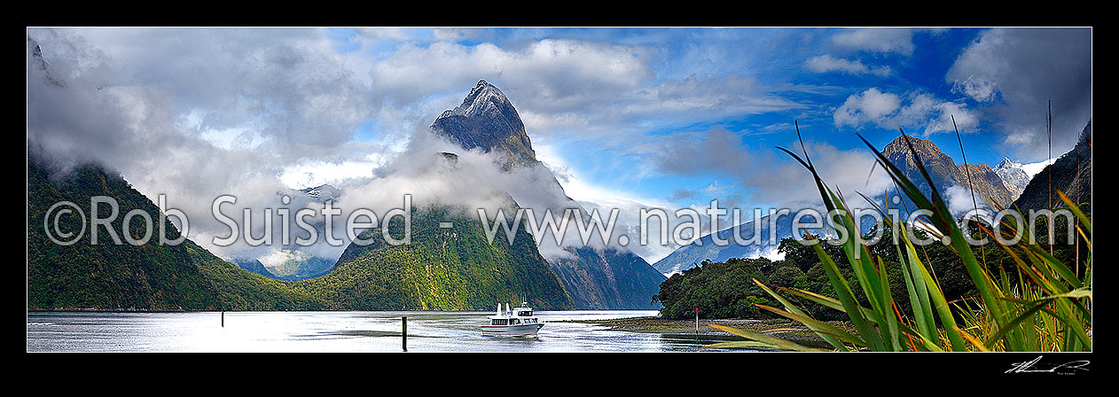 Image of Milford Sound Panorama in clearing weather, Fiordland National Park. Small boat below Mitre Peak (1683m) entering Freshwater Basin. Sinbad Gully valley left., Milford Sound, Fiordland National Park, Southland District, Southland Region, New Zealand (NZ) stock photo image