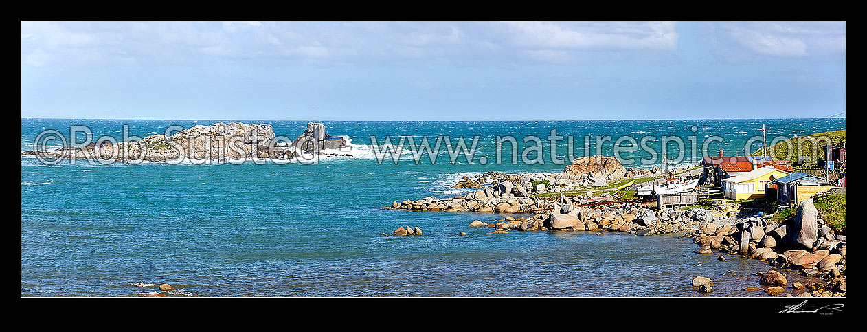 Image of Cosy Nook village nestled into a natural harbour on the Southern Scenic Route near Colac Bay. Small historic fishing village with cribs / baches. Panorama, Cosy Nook, Southland District, Southland Region, New Zealand (NZ) stock photo image