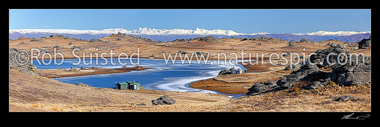 Image of Poolburn reservior frozen in winter. Fishing baches and cribs around edge. Lord of the Rings location Rohan. Panorama, Ida Burn Valley, Central Otago District, Otago Region, New Zealand (NZ) stock photo image