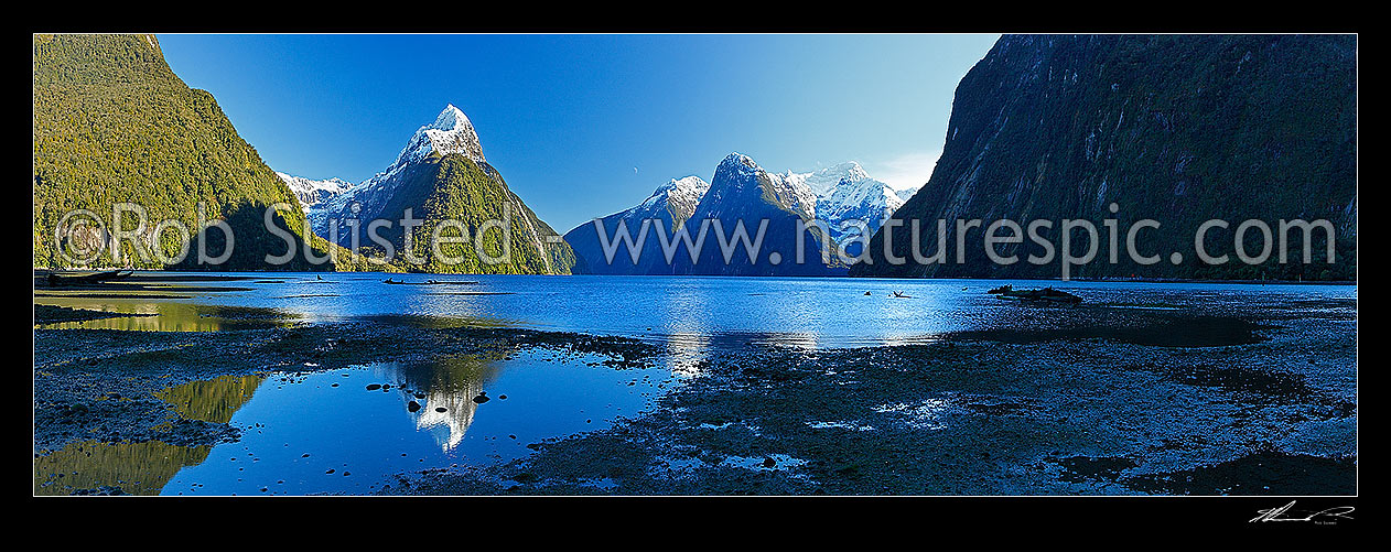 Image of Mitre Peak reflecting in Milford Sound. Mitre Peak left (1683m), Stirling Falls centre, The Lion (1302m) and Mt Pembroke (2015m) right centre. Panorama, Milford Sound, Fiordland National Park, Southland District, Southland Region, New Zealand (NZ) stock photo image