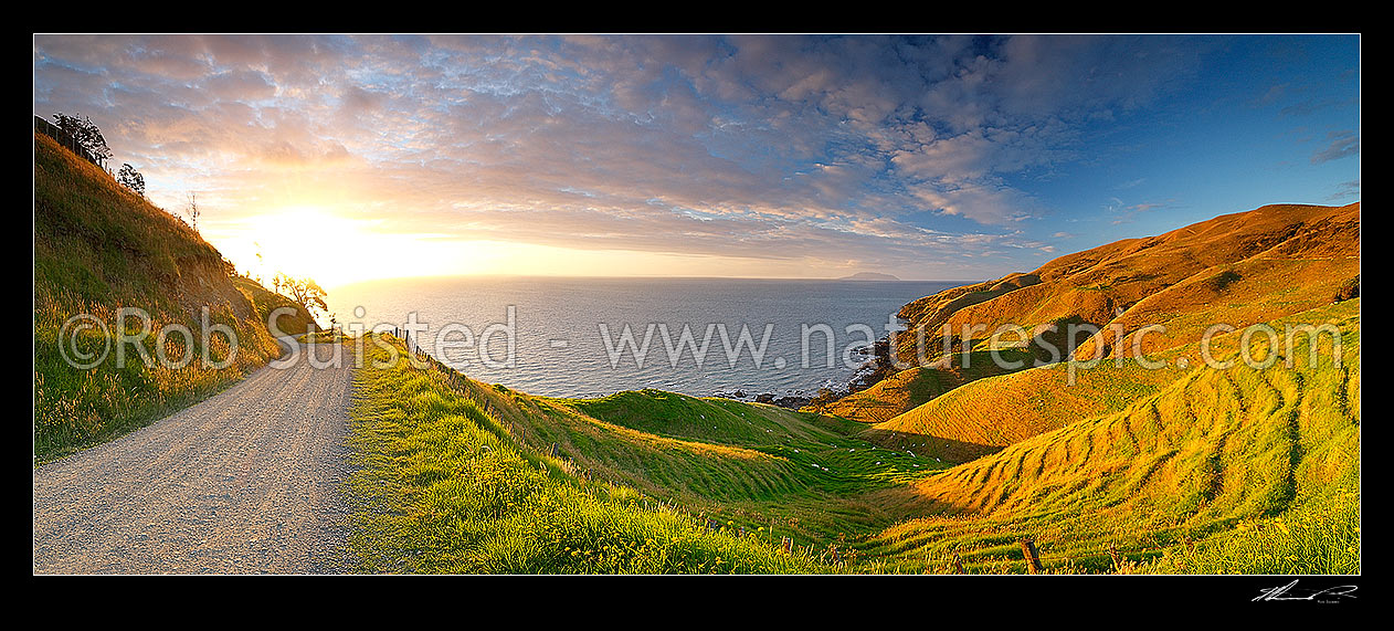 Image of Coromandel panorama looking north from near Cape Colville to Little Barrier Island (Hauturu) on beaut summer evening sunset. Farmland and dirt road, Cape Colville, Thames-Coromandel District, Waikato Region, New Zealand (NZ) stock photo image