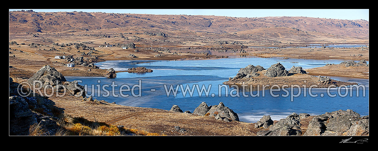 Image of Poolburn reservior frozen in winter. Fishing baches and cribs around edge. Lord of the Rings location Rohan. Panorama, Ida Burn Valley, Central Otago District, Otago Region, New Zealand (NZ) stock photo image