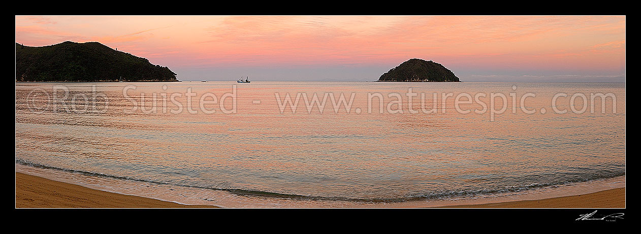 Image of Abel Tasman sunset at Onetahuti Beach, with Tonga Island and Reef Point beyond. Tonga Roadstead. Fishing boat moored in bay. Panorama, Abel Tasman National Park, Tasman District, Tasman Region, New Zealand (NZ) stock photo image