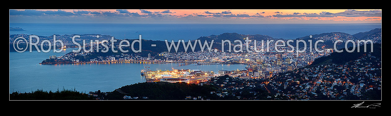 Image of Wellington Harbour, CBD and City at twilight with lights glowing. Panorama from Evans Bay / airport to Wadestown (right), Cook Strait beyond, Wellington City, Wellington City District, Wellington Region, New Zealand (NZ) stock photo image