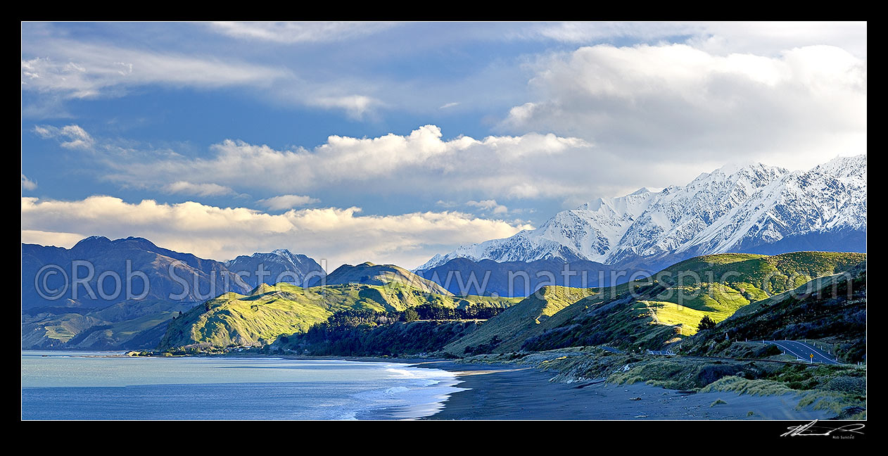 Image of Kaikoura Coastline. Later afternoon winter sun on the snowy Seaward Kaikoura Range, beach and coastal farmland near Kekerengu and Clarence. Panorama, Kaikoura, Kaikoura District, Canterbury Region, New Zealand (NZ) stock photo image