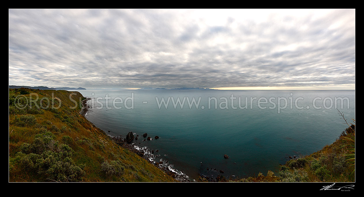 Image of Looking across Cook Strait from Mana Island to the South Island with dramatic sky and clouds. Panorama, Mana Island, Porirua City District, Wellington Region, New Zealand (NZ) stock photo image