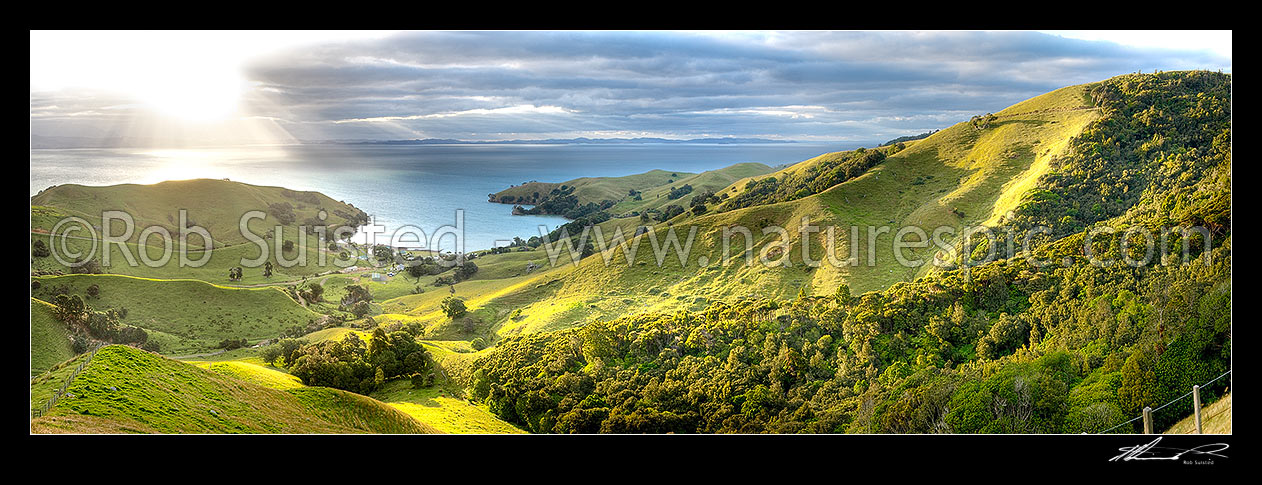 Image of Hauraki Gulf panorama. Moody sunshafts and clouds over sea near Kirita Bay, Coromandel Peninsula, looking towards Auckland. Stunning lush farmland panorama, Coromandel, Thames-Coromandel District, Waikato Region, New Zealand (NZ) stock photo image