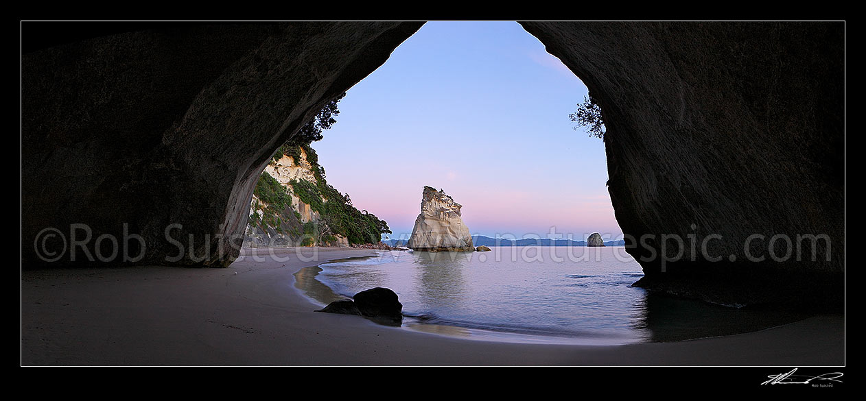 Image of Cathedral Cove peaceful pre dawn morning panorama looking through rock tunnel or cave. Coromandel Peninsula, Hahei, Coromandel Peninsula, Thames-Coromandel District, Waikato Region, New Zealand (NZ) stock photo image