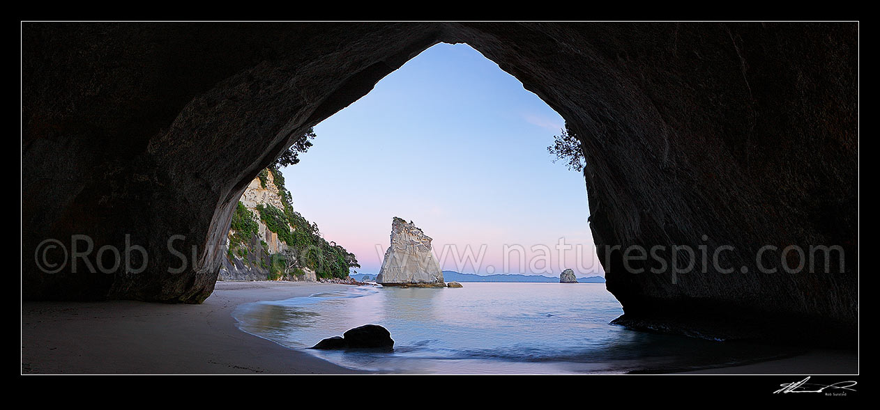 Image of Cathedral Cove peaceful pre dawn morning panorama looking through rock tunnel or cave. Coromandel Peninsula, Hahei, Coromandel Peninsula, Thames-Coromandel District, Waikato Region, New Zealand (NZ) stock photo image