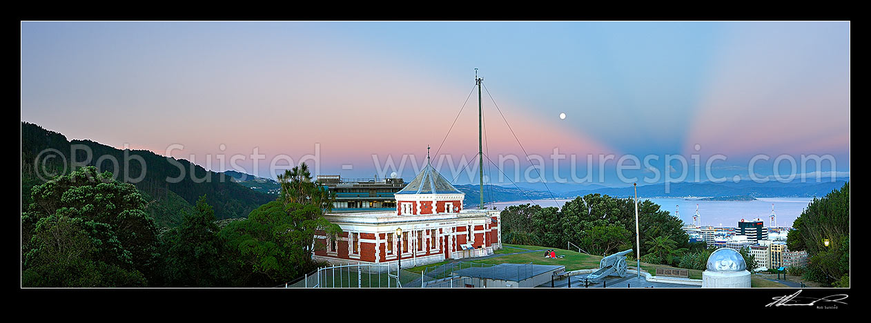 Image of Historic Dominion Observatory built 1907 in Edwardian Baroque style to house the time service. The Krupp gun and Garden Battery to right. Panorama over harbour at dusk with moonrise, Wellington, Wellington City District, Wellington Region, New Zealand (NZ) stock photo image