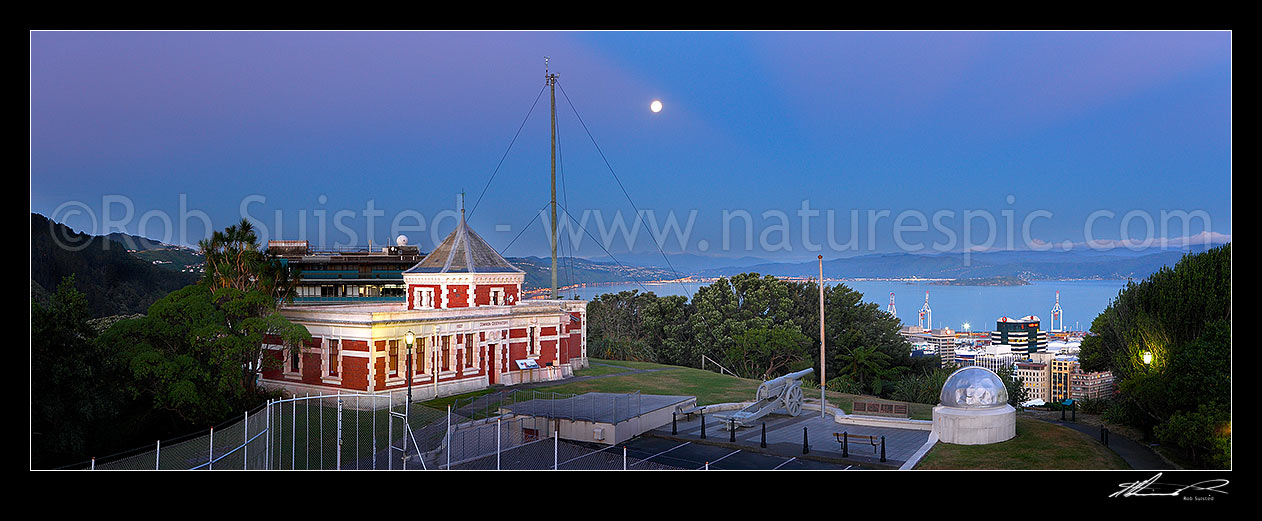 Image of Historic Dominion Observatory built 1907 in Edwardian Baroque style to house the time service. The Krupp gun and Garden Battery to right. Panorama over harbour at dusk with moonrise, Wellington, Wellington City District, Wellington Region, New Zealand (NZ) stock photo image