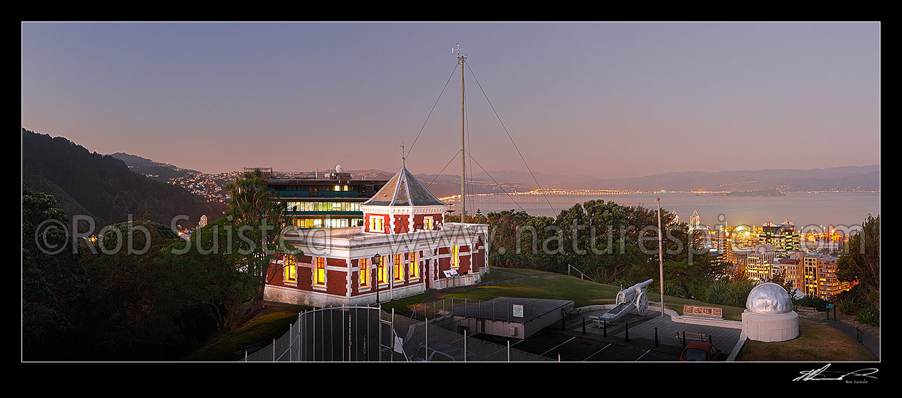 Image of Historic Dominion Observatory built 1907 in Edwardian Baroque style to house the time service. The Krupp gun and Garden Battery to right. Panorama over harbour at dusk, Wellington, Wellington City District, Wellington Region, New Zealand (NZ) stock photo image