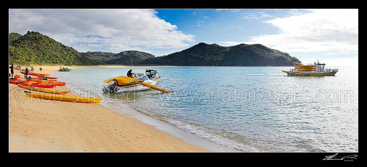 Image of Onetahuti Beach, with water taxis and boats unloading sea kayaks for day kayakers. Panorama, Abel Tasman National Park, Tasman District, Tasman Region, New Zealand (NZ) stock photo image