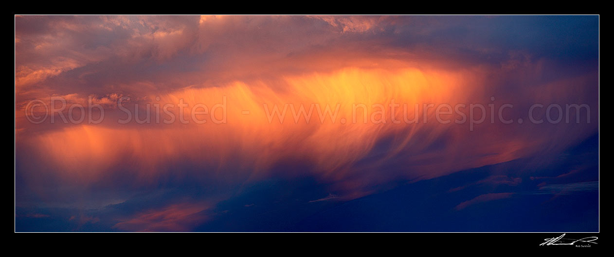 Image of Unusual wispy orange sunset clouds in an evening sky. Panorama file, New Zealand (NZ) stock photo image