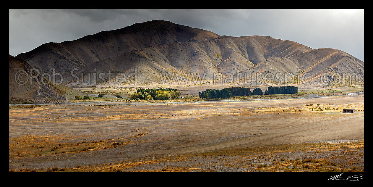 Image of Red Gate hut, airstrip and barn in the Severn River Valley (Alma River far left) with breaking weather and sun. Panorama, Molesworth Station, Marlborough District, Marlborough Region, New Zealand (NZ) stock photo image