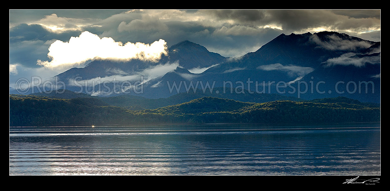 Image of Lake Te Anau and Fiordland, with the Murchison Mountains beyond as mist lifts in the evening. Mt Owen centre. Panorama, Fiordland National Park, Southland District, Southland Region, New Zealand (NZ) stock photo image