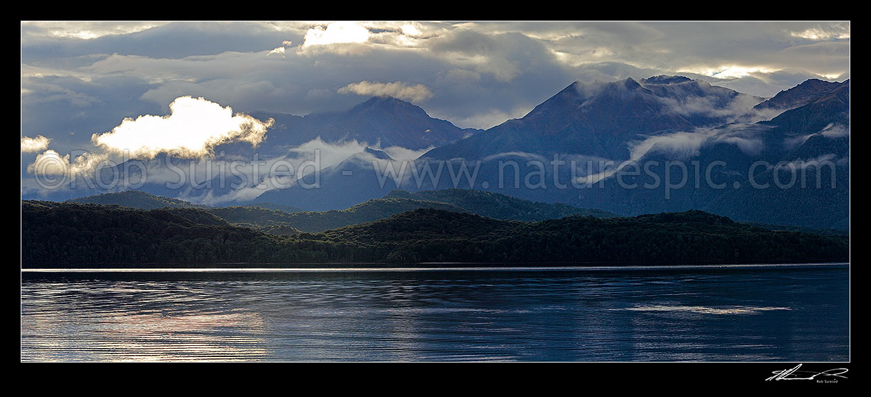 Image of Lake Te Anau and Fiordland, with the Murchison Mountains beyond as mist lifts in the evening. Mt Owen centre. Panorama, Fiordland National Park, Southland District, Southland Region, New Zealand (NZ) stock photo image