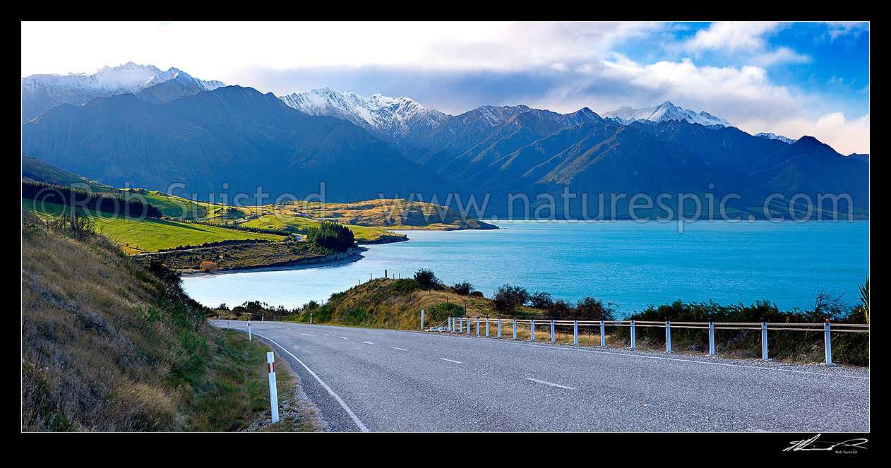 Image of Lake Hawea in beautiful sunlight, with State Highway 6 (Makarora Lake Hawea Road) heading for Haast Pass. Panorama, Lake Hawea, Otago, Queenstown Lakes District, Otago Region, New Zealand (NZ) stock photo image