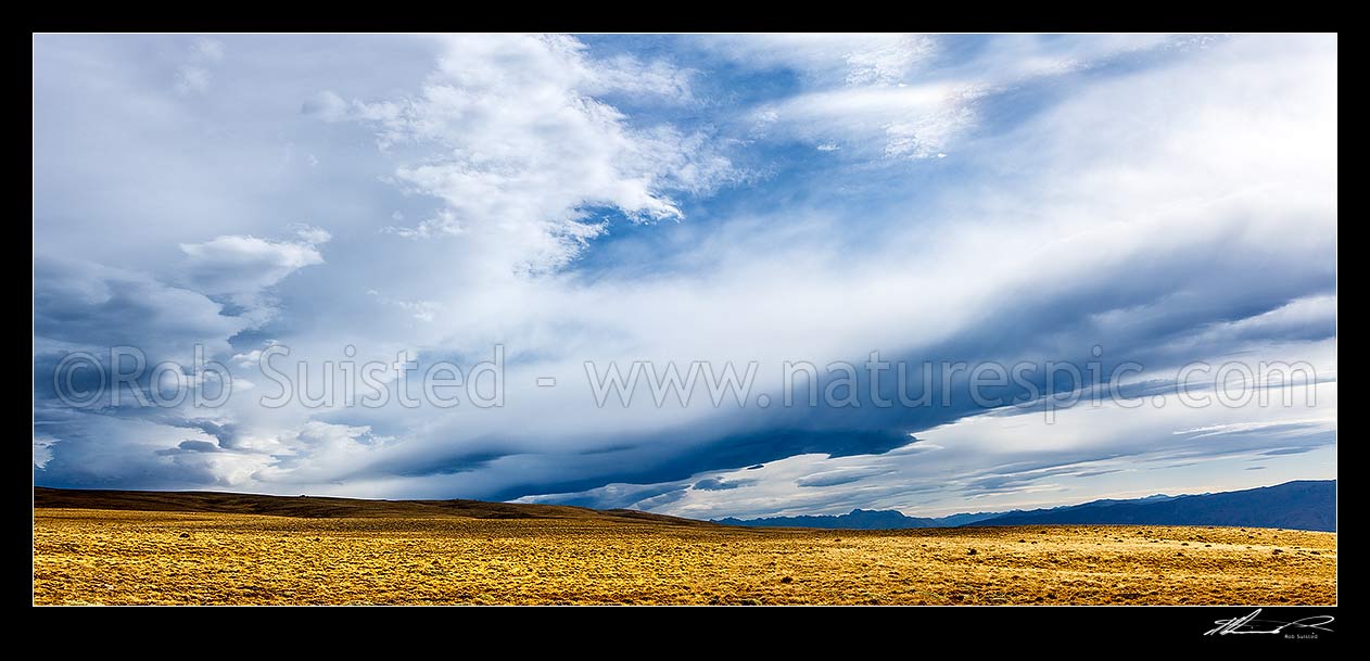 Image of Mount Moka, Bendigo Conservation Area, on the Dunstan Mountains Range. Alpine and tussock grassland panorama with dramatic clouds and impending snow, Bendigo, Central Otago District, Otago Region, New Zealand (NZ) stock photo image