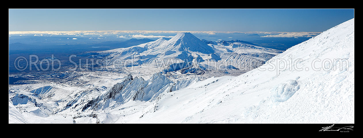 Image of Mount Ngauruhoe panorama seen from above Whakapapa skifeild in winter. Tama Lakes centre and Pinnacle Ridge on Mt Ruapehu centre. Mt Tongariro and Lake Taupo beyond, Tongariro National Park, Ruapehu District, Manawatu-Wanganui Region, New Zealand (NZ) stock photo image