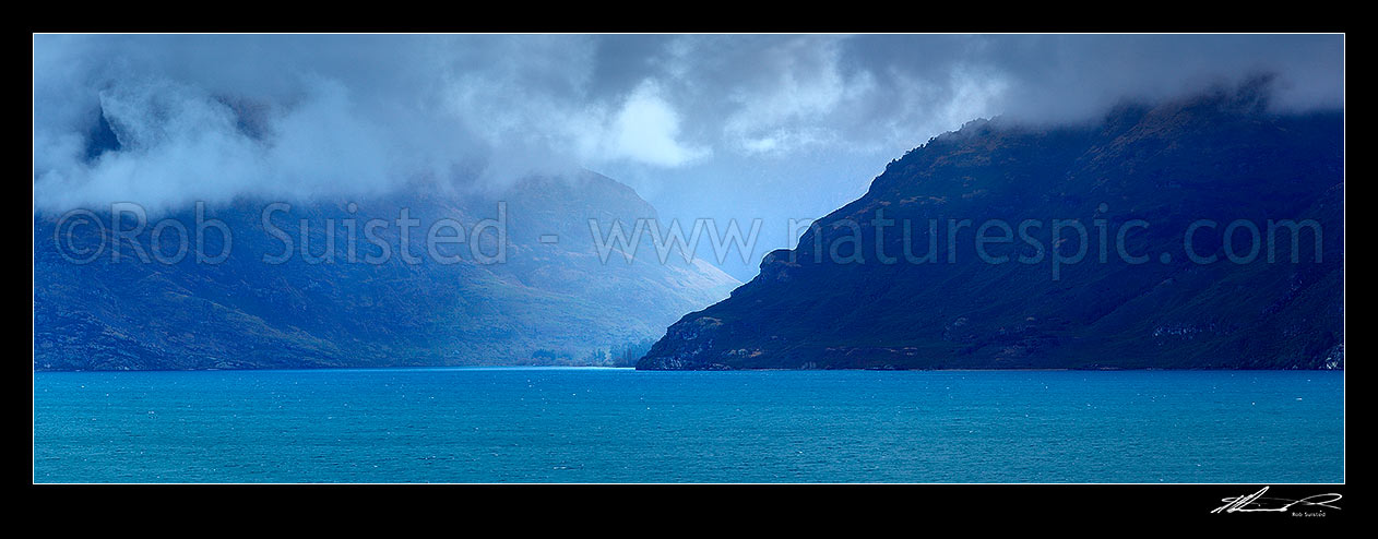 Image of Lake Wakatipu moody looking across to clearing weather at the Lochy River and Halfway Bay Station on a bleak winters day. Panorama, Kingston, Queenstown Lakes District, Otago Region, New Zealand (NZ) stock photo image