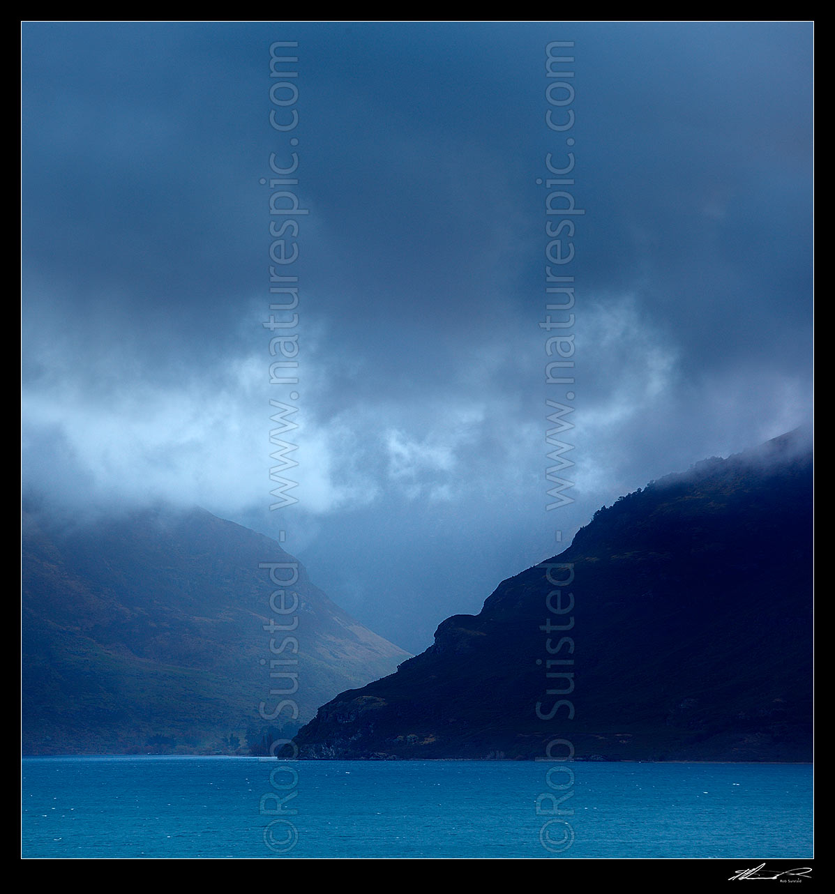 Image of Lake Wakatipu moody looking across to clearing weather at the Lochy River and Halfway Bay Station on a bleak winters day. Square format, Kingston, Queenstown Lakes District, Otago Region, New Zealand (NZ) stock photo image