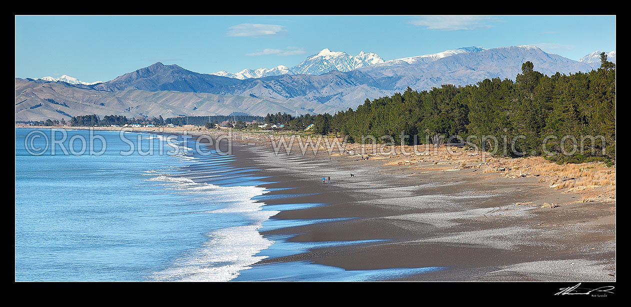 Image of Rarangi Beach with walkers in Cloudy Bay with Wither Hills, Mount Tapuae-o-uenuku (2885m) and Inland Kaikoura Ranges above. Panorama, Rarangi, Marlborough District, Marlborough Region, New Zealand (NZ) stock photo image