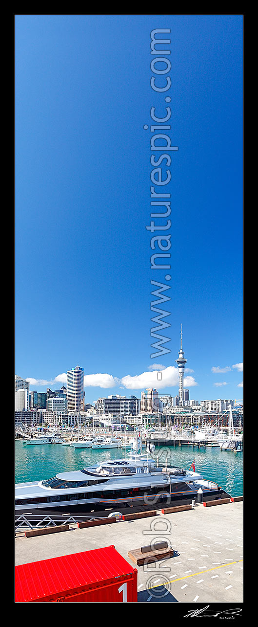 Image of Auckland City waterfront and Viaduct Harbour vertical panorama, with boat and yachts moored in Viaduct Harbour. Wynyard Crossing bridge at right. The Auckland Skytower above, Auckland City, Auckland City District, Auckland Region, New Zealand (NZ) stock photo image