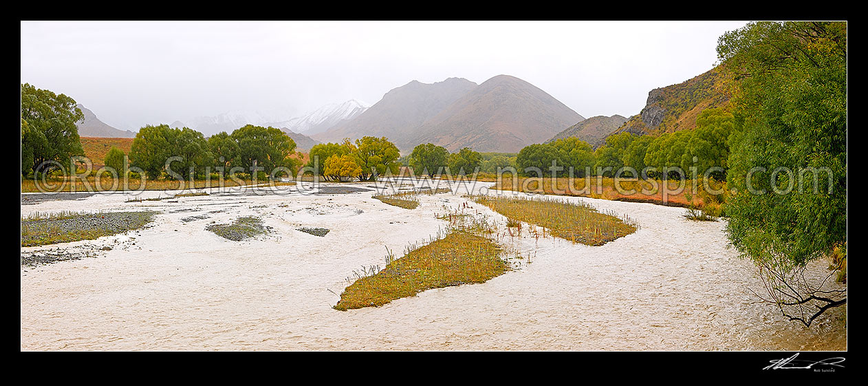 Image of Upper Awatere River in flood. With unseasonal snow on peaks above Yeo Stream. Panorama, Molesworth Station, Marlborough District, Marlborough Region, New Zealand (NZ) stock photo image