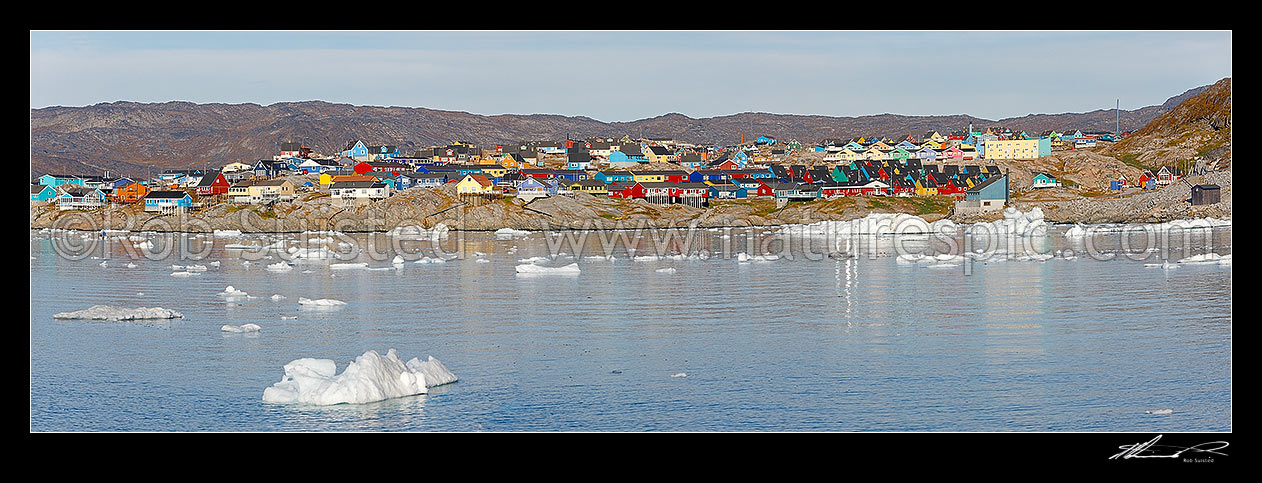 Image of Ilulissat township seen from the sea, with bright coloured houses on hills with ice floating in water from Jakobshavn Isbr (Jakobshavn Glacier) Panorama, Ilulissat, Greenland stock photo image