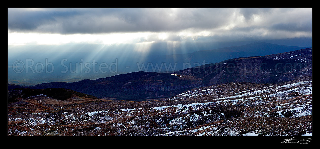 Image of Lake Surprise and Maungaturuturu River valley lit by sun shafts behind a passing weather front on the flanks of Mount Ruapehu near Ohakune. Panorama, Tongariro National Park, Ruapehu District, Manawatu-Wanganui Region, New Zealand (NZ) stock photo image