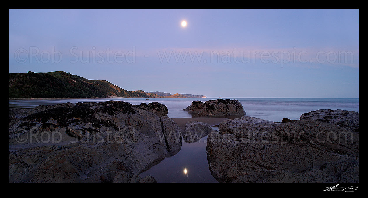 Image of Port Awanui moonrise reflected in rockpool. Te Wharau Beach, Whakaumu Peak, East Cape and East Island (Whangaokeno) visible in distance. Panorama, Port Awanui, East Coast, Gisborne District, Gisborne Region, New Zealand (NZ) stock photo image