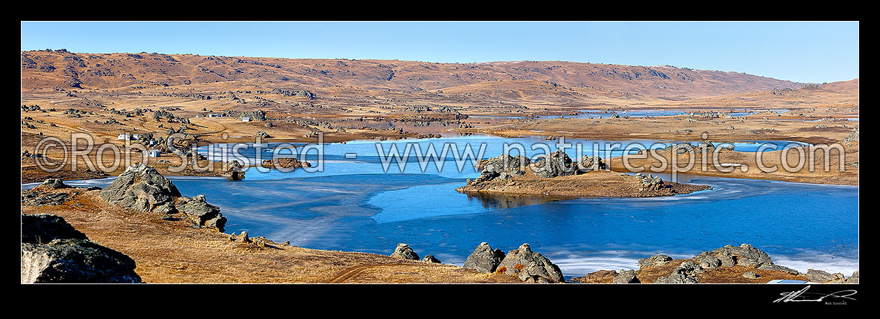 Image of Poolburn reservior frozen in winter with fishing baches and cribs around edge, used as the Lord of the Rings location Rohan. Panorama, Ida Burn Valley, Central Otago District, Otago Region, New Zealand (NZ) stock photo image