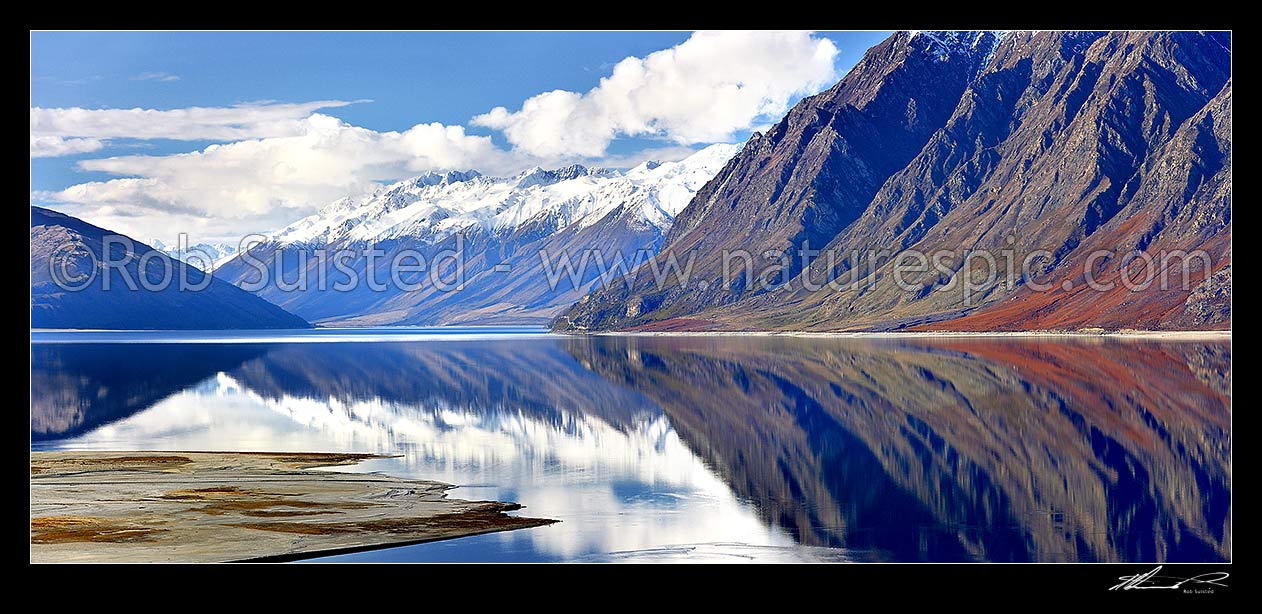 Image of Lake Hawea with the snow covered Huxley Range and mountains reflecting in lake. Hunter River Valley far left. Panorama, Lake Hawea, Otago, Queenstown Lakes District, Otago Region, New Zealand (NZ) stock photo image