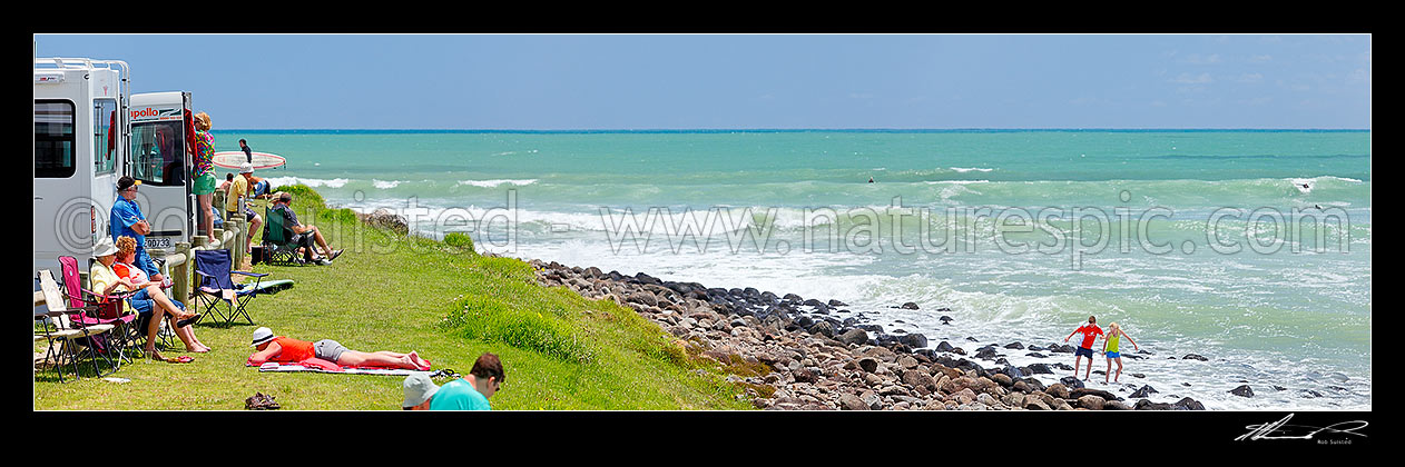 Image of Manu Bay surf break with surfers and spectators enjoying the summer sun. Panorama, Raglan, Waikato District, Waikato Region, New Zealand (NZ) stock photo image