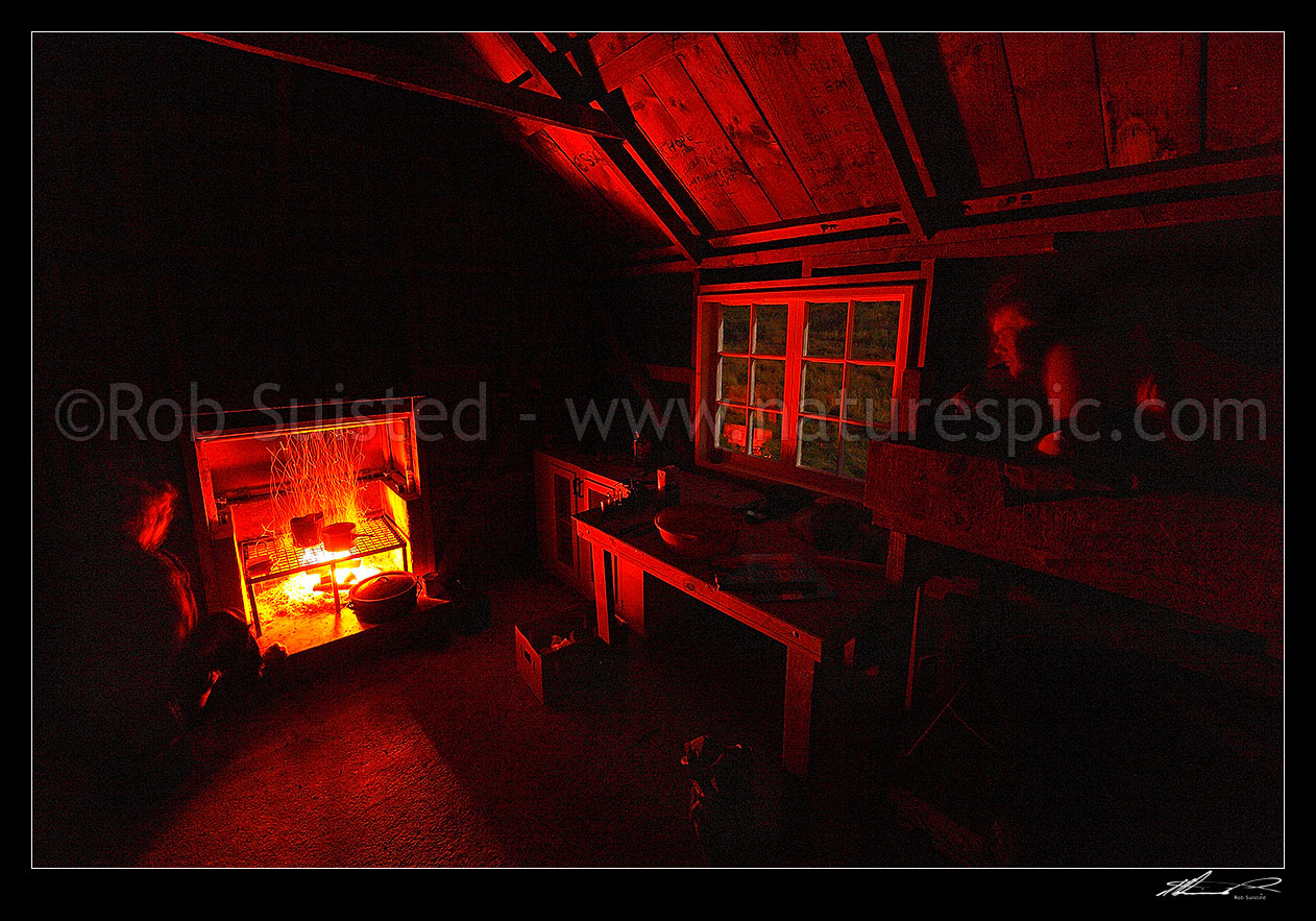 Image of Breakfast cooking in historic Yarra Hut at 4.30am during late summer steer muster. Stockman Dan Jury, watched by James Mclachlan, Molesworth Station, Marlborough District, Marlborough Region, New Zealand (NZ) stock photo image