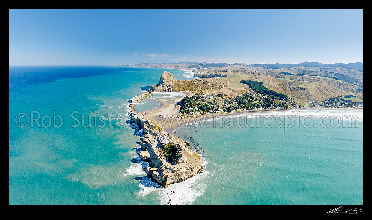 Image of Castlepoint lighthouse, reef, lagoon and village, and Castle Rock (162m). Castlepoint Scenic Reserve. Aerial panorama looking south, Castlepoint, Masterton District, Wellington Region, New Zealand (NZ) stock photo image