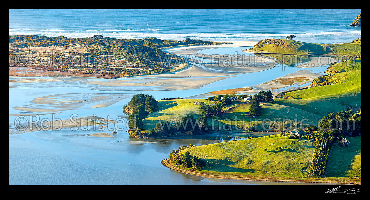 Image of Otago Peninsula farmland, houses and beaches around Hoopers Inlet mouth on a perfect calm later winter morning. Allans Beach left. Panorama, Otago Peninsula, Dunedin City District, Otago Region, New Zealand (NZ) stock photo image