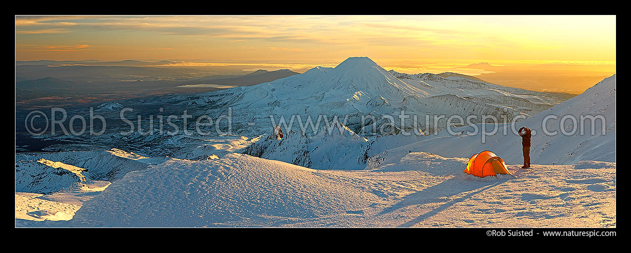 Image of Mount Ngauruhoe sunrise (2287m) from alpine tent camp near summit of Mt Ruapehu. Mt Tongariro (1967m) and Lake Taupo behind. Heavy winter snow. Panorama, Tongariro National Park, Ruapehu District, Manawatu-Wanganui Region, New Zealand (NZ) stock photo image