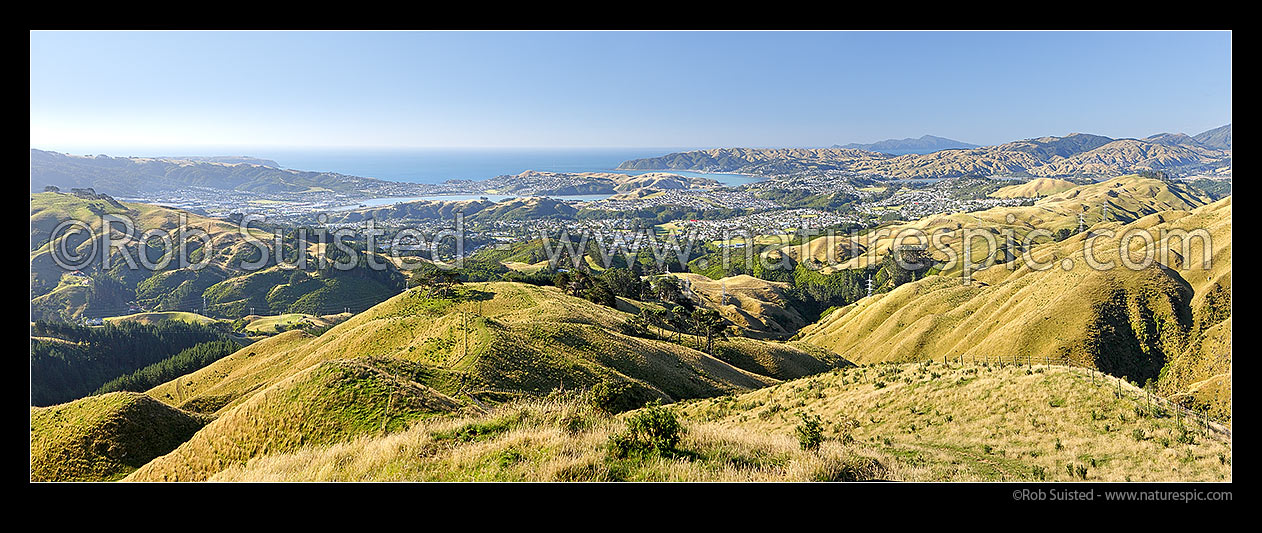 Image of Porirua City panorama. Porirua East, Aotea, Paremata, Plimmerton, Whitby, Pauatahanui Inlet, with Kapiti Island distant. From Belmont Regional Park showing Transmission Gully Road route, Porirua, Porirua City District, Wellington Region, New Zealand (NZ) stock photo image