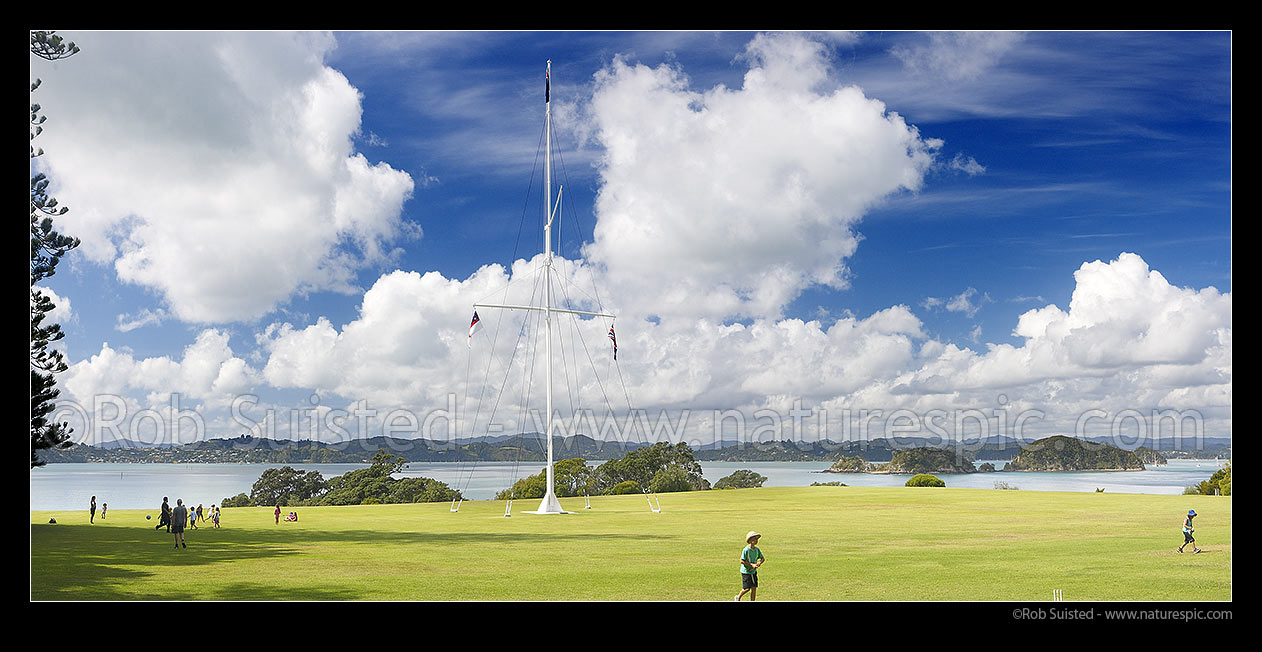 Image of Waitangi Treaty Grounds with visiting school children. Naval flagstaff standing where Te Tiriti o Waitangi (Treaty of Waitangi) was signed. Panorama, Waitangi, Bay of Islands, Far North District, Northland Region, New Zealand (NZ) stock photo image