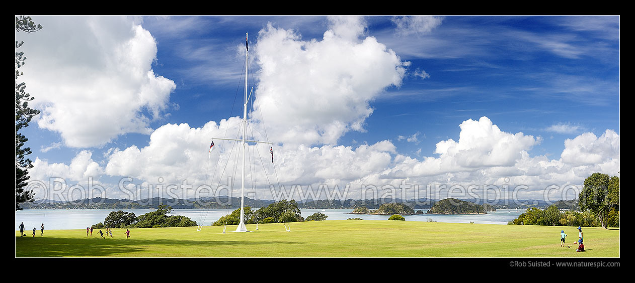 Image of Waitangi Treaty Grounds with visiting school children. Naval flagstaff standing where Te Tiriti o Waitangi (Treaty of Waitangi) was signed. Panorama, Waitangi, Bay of Islands, Far North District, Northland Region, New Zealand (NZ) stock photo image