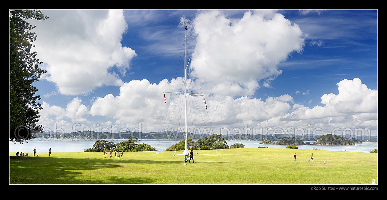 Image of Waitangi Treaty Grounds with visiting school children. Naval flagstaff standing where Te Tiriti o Waitangi (Treaty of Waitangi) was signed. Panorama, Waitangi, Bay of Islands, Far North District, Northland Region, New Zealand (NZ) stock photo image