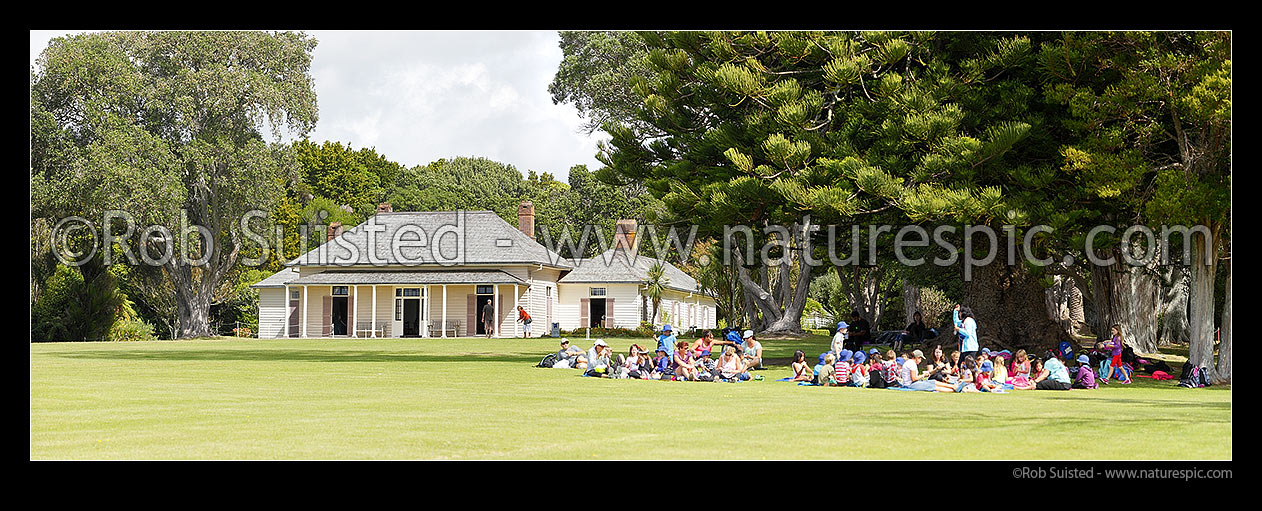 Image of The Treaty House (1834) in the Waitangi Treaty Grounds with visiting school children visiting. Te Tiriti o Waitangi. Panorama, Waitangi, Bay of Islands, Far North District, Northland Region, New Zealand (NZ) stock photo image