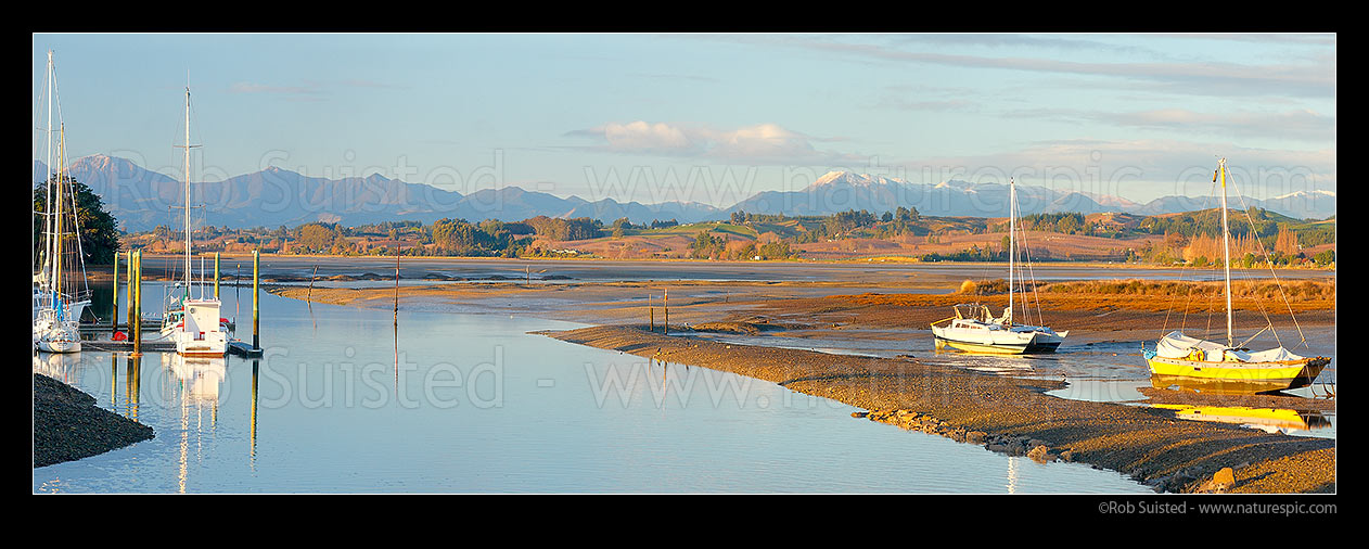 Image of Port Motueka Marina with boats moored in Moutere Inlet at low tide. Richmond Range in distance. Panorama, Motueka, Tasman District, Tasman Region, New Zealand (NZ) stock photo image